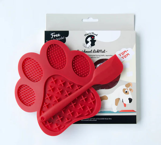 Non slip red lick mat out of packet. Sitting on top of packet on white background